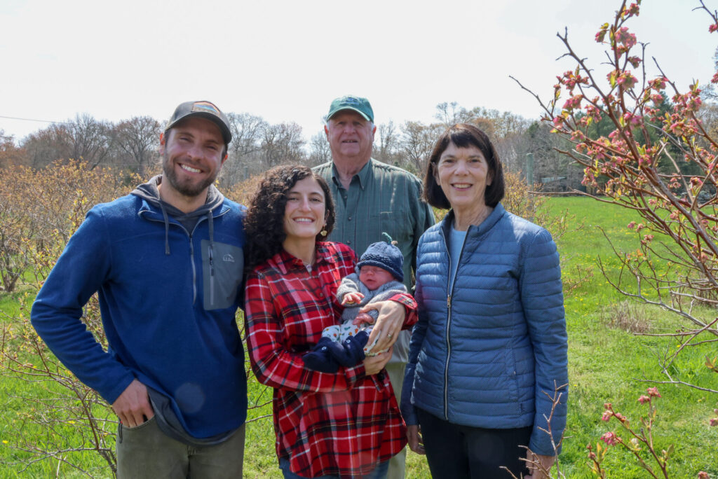 smiling adults with baby at blueberry farm